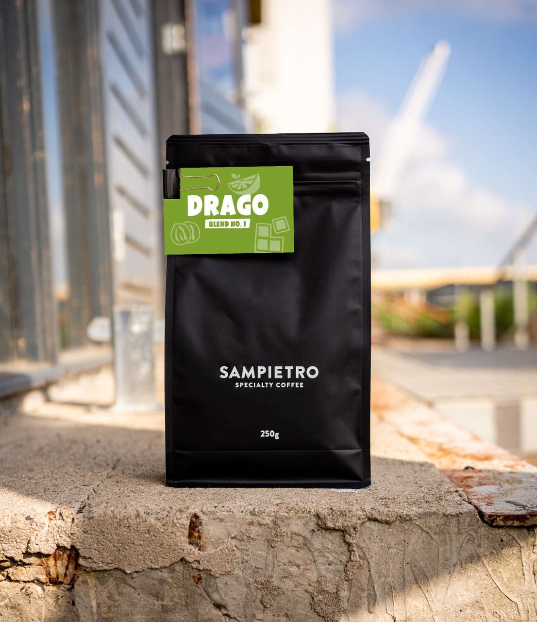 Productfotografie van Sampietro specialty koffie – zwarte verpakking met label 'Drago Blend No.1' in industriële setting